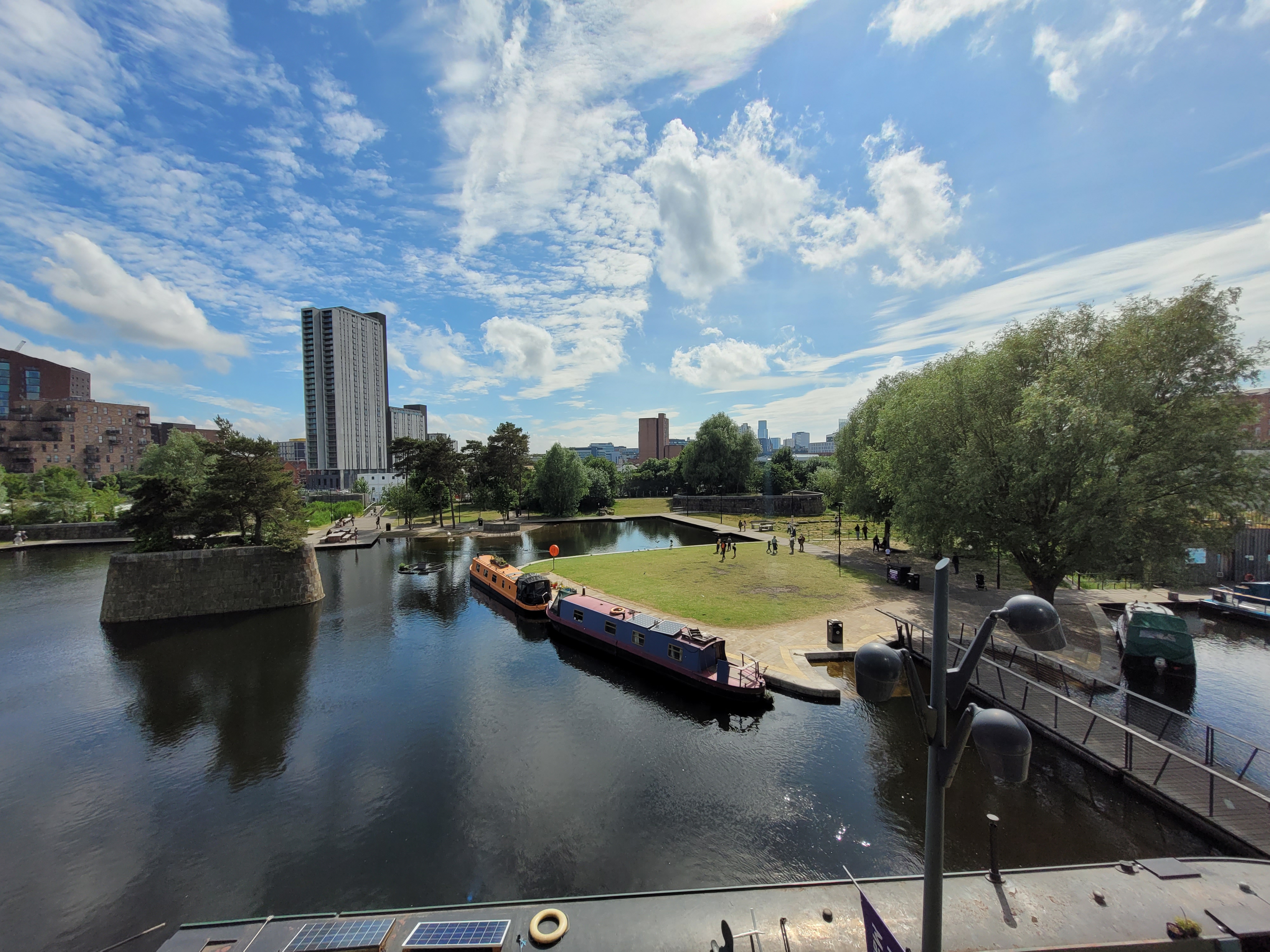 Views over Ancoats Marina with canal boats and Manchester City Centre